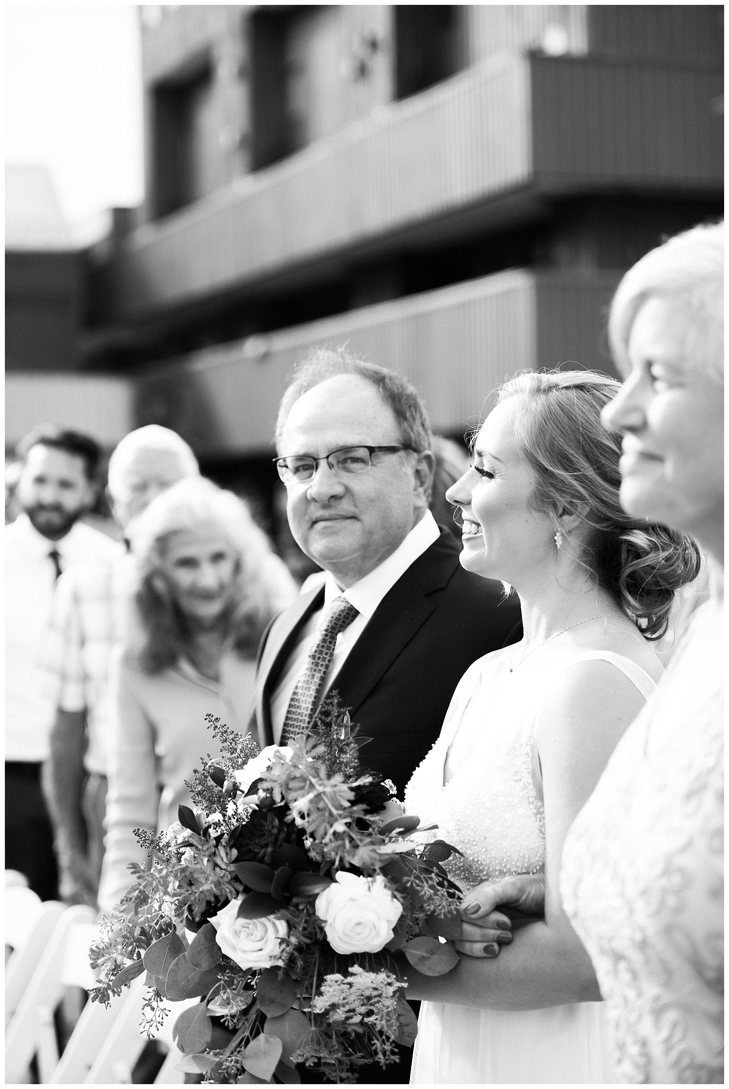 Father and mother walking daughter down the aisle at outside wedding ceremony at Sugarloaf Mountain Resort in Maine, photos by Halie Olszowy.