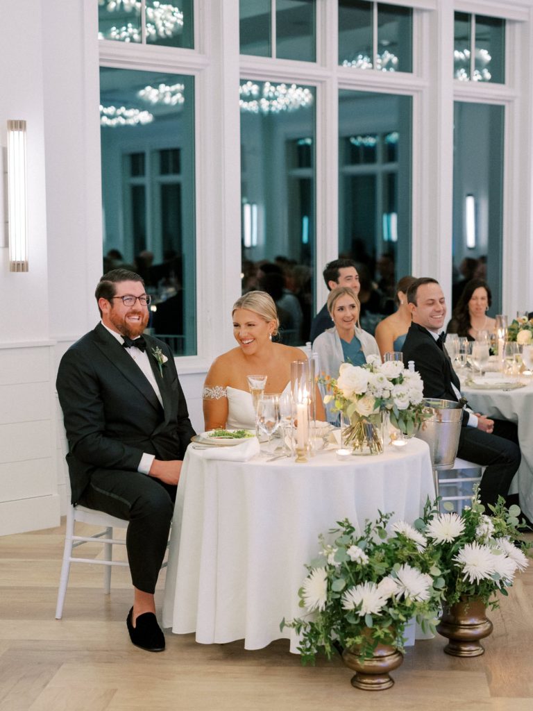 Bride and groom at sweetheart table during speeches