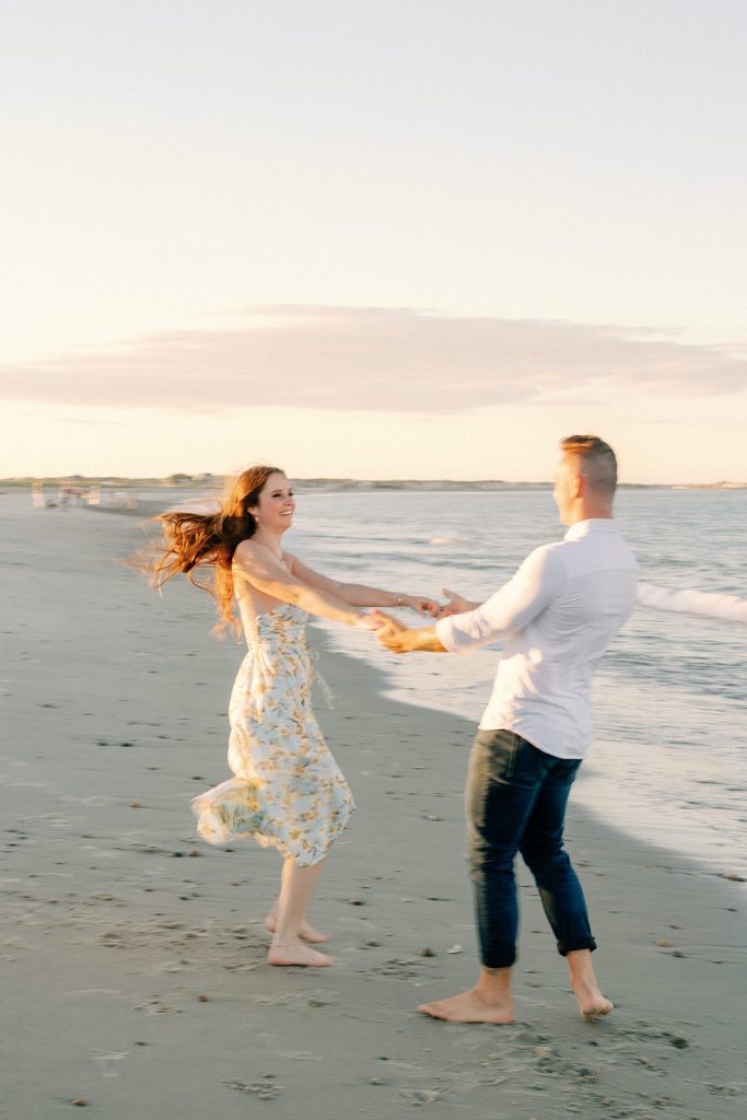 Couple dancing on the beach fr their engagement photos