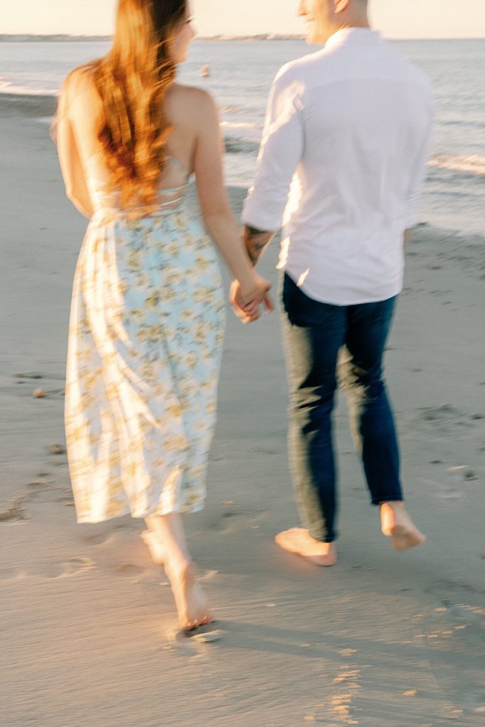 Couple walking on the beach with some motion blur in the photo