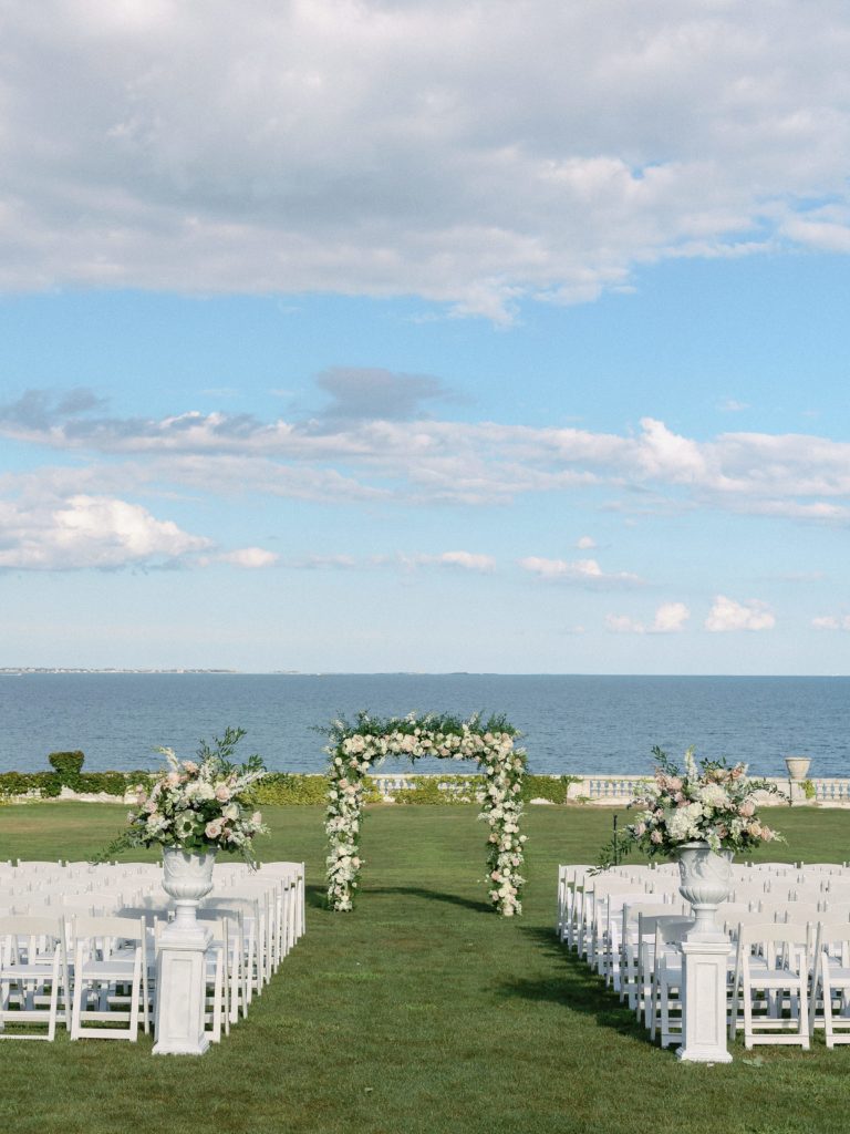 Outdoor ceremony at Rosecliff Newport Mansion with floral arbor 
