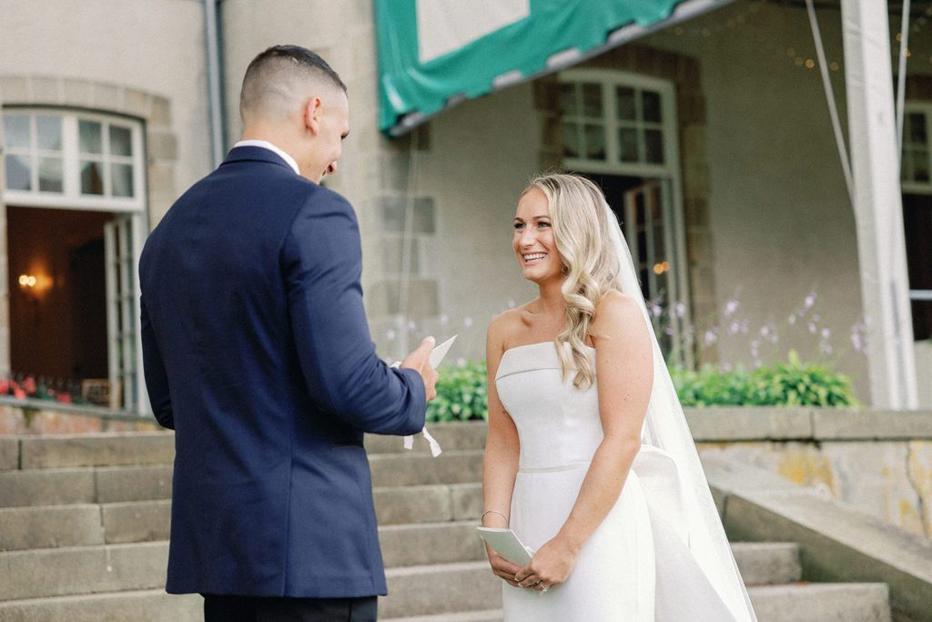 Bride and groom reading vows privately to each other during first look