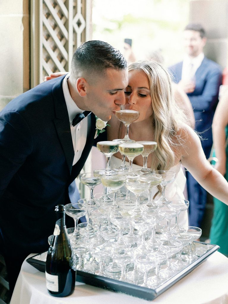 Bride and groom pouring champagne into champagne tower for Newport estate wedding