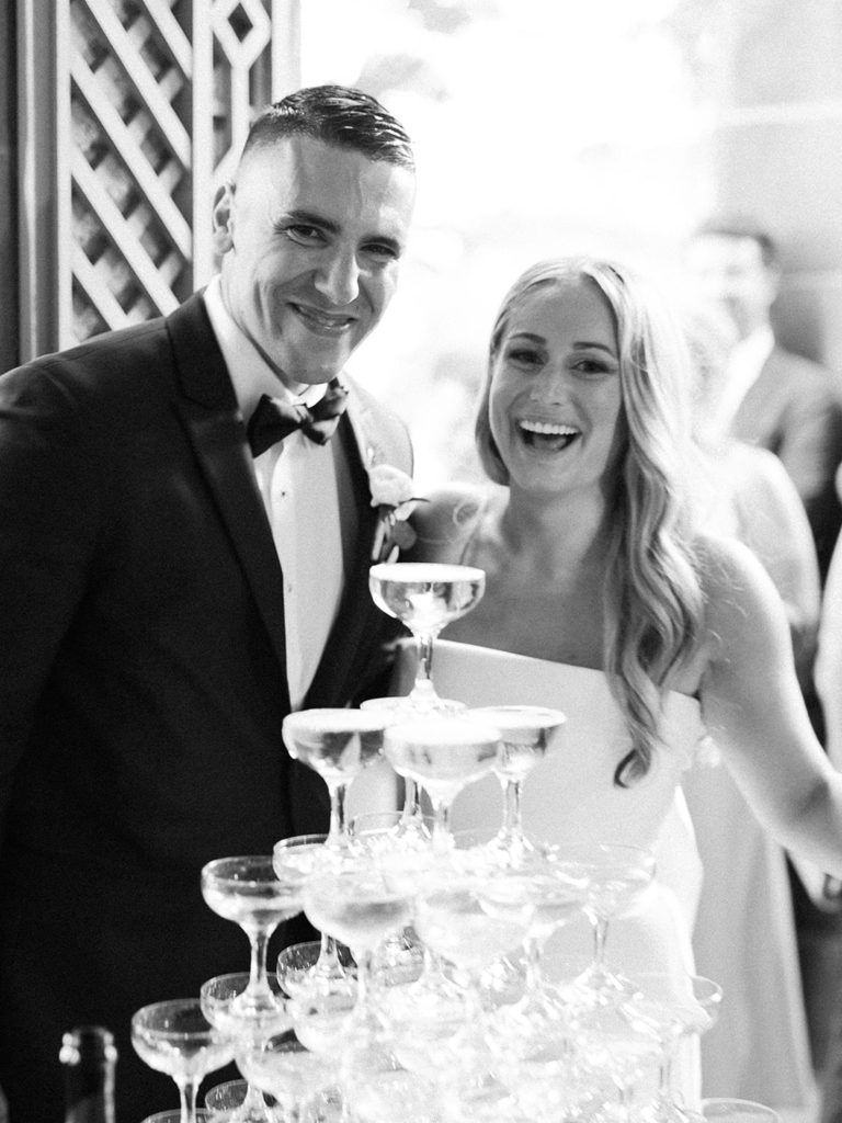 Bride and groom pouring champagne into champagne tower for Newport estate wedding