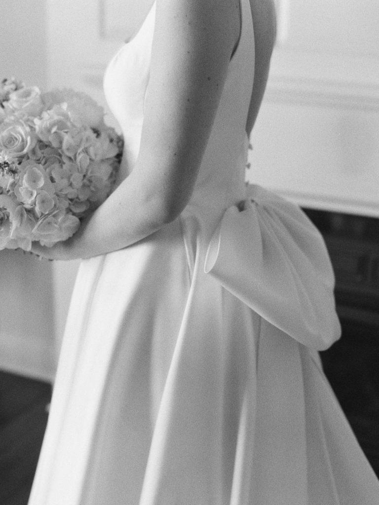 Black and white photo of brides gown with bow detail on the back 
