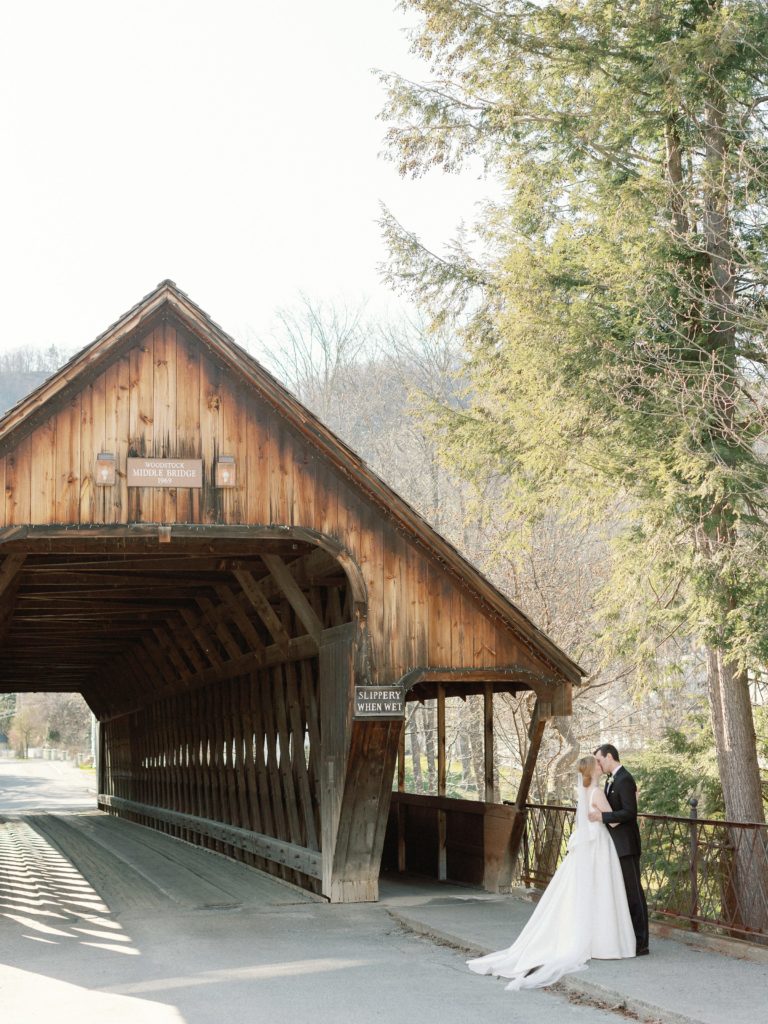 Bride and groom portrait in front of covered bridge in Woodstock, Vermont
