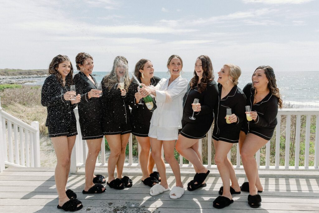 Bride and bridesmaids popping champagne for Newport wedding