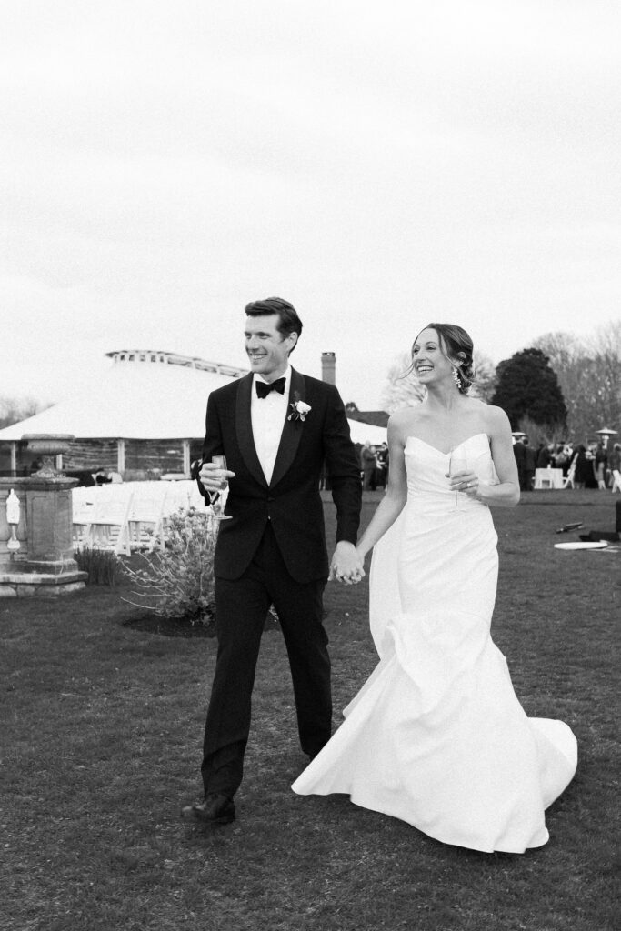 Candid black and white photo of bride and groom at cocktail hour