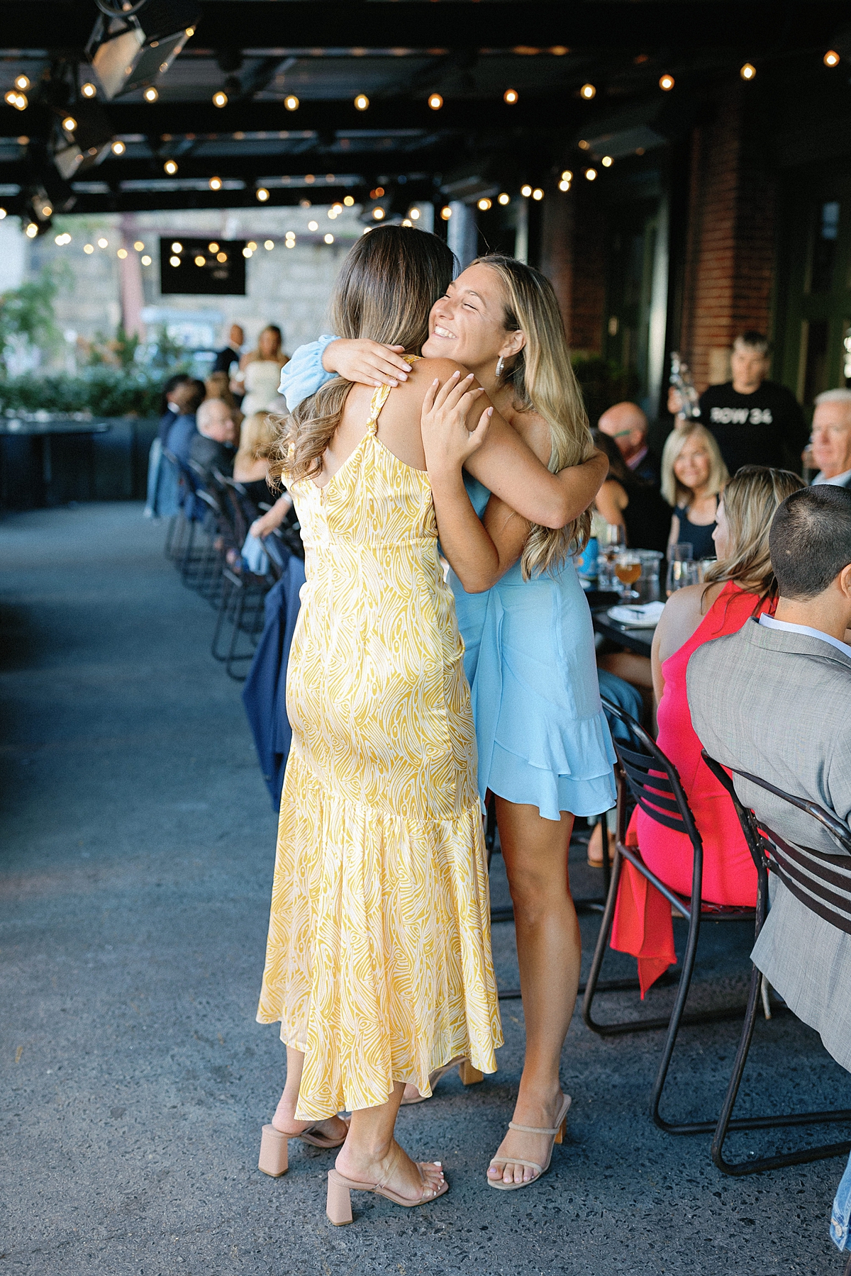 Two woman hugging at rehearsal dinner