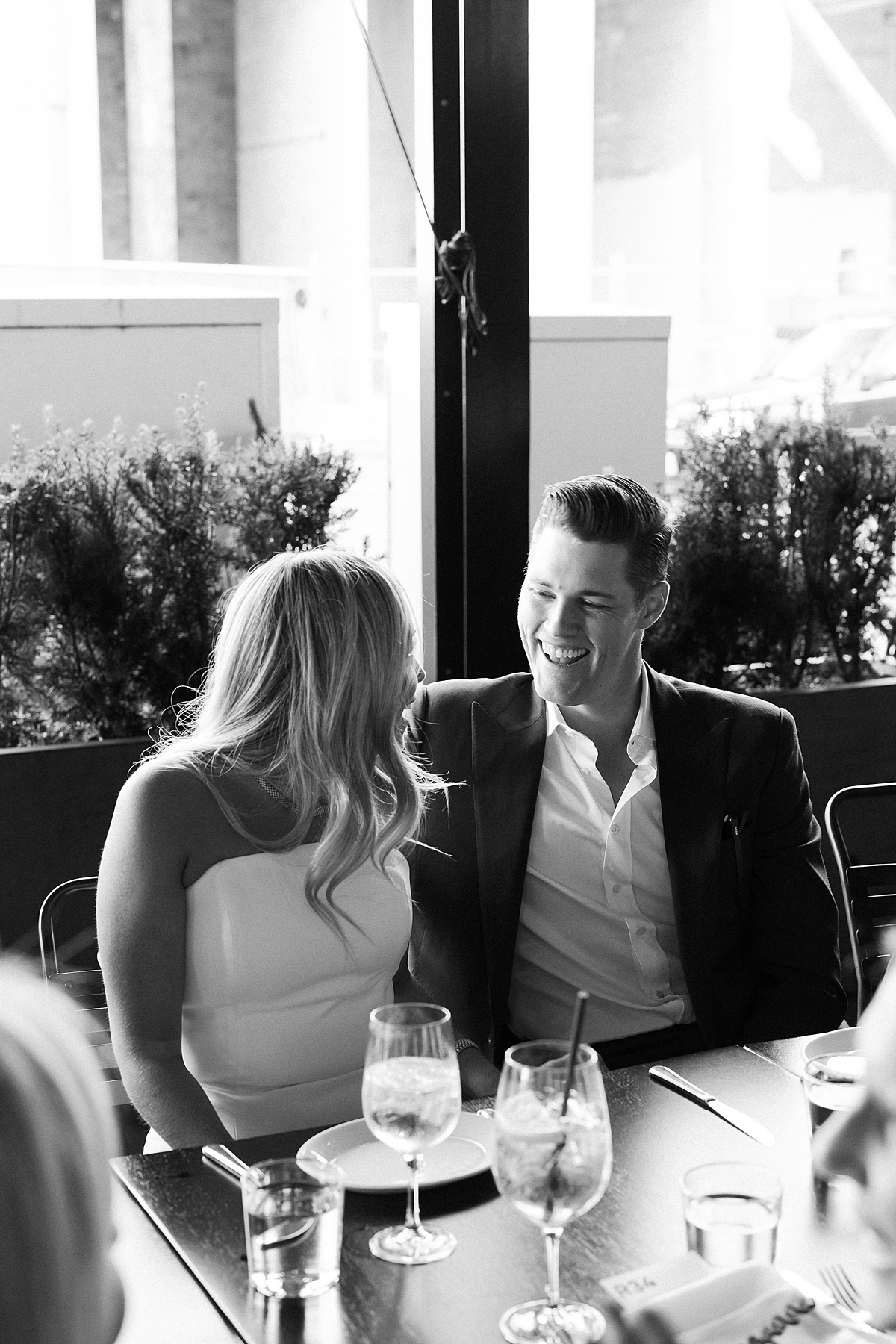 Bride and groom smiling at each other at their rehearsal dinner