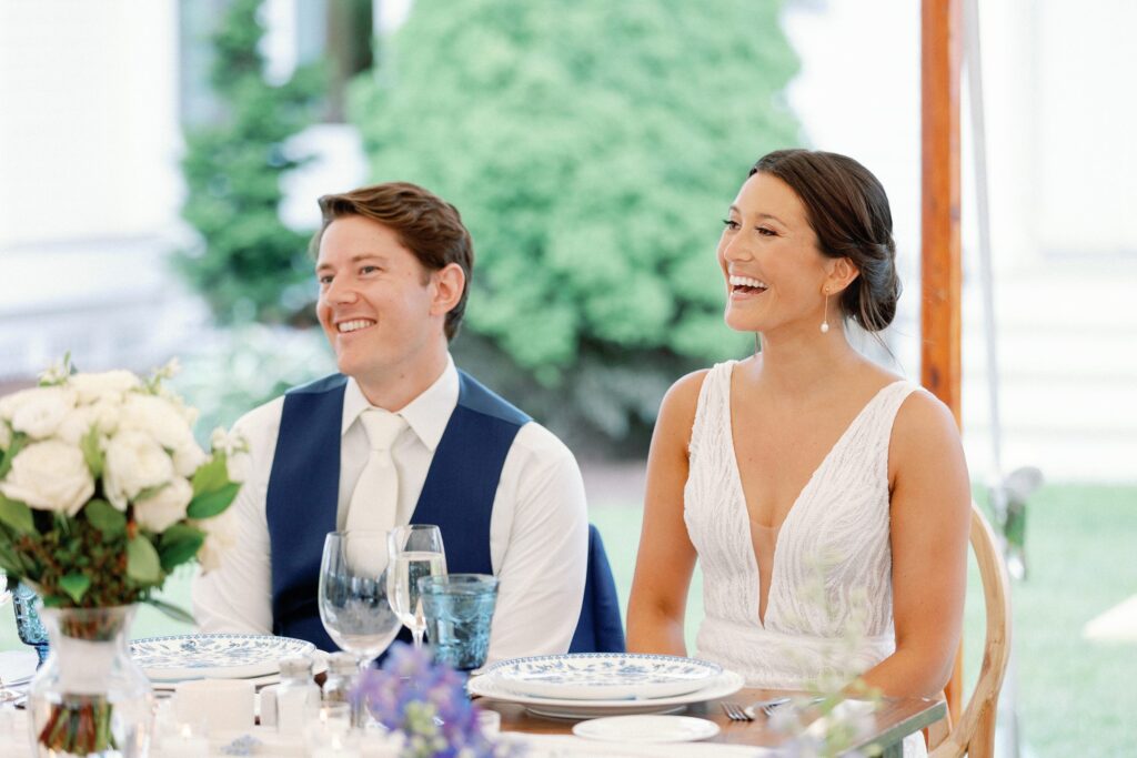 Bride and groom's faces during speeches for Coastal New England Tented Wedding