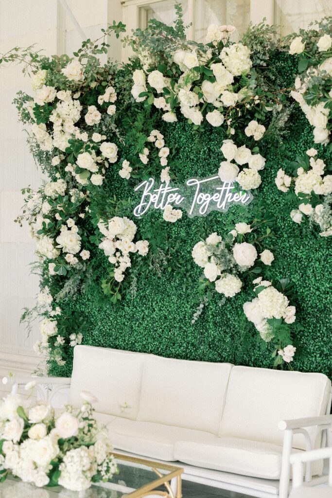 Floral wall with "Better Together" neon sign 