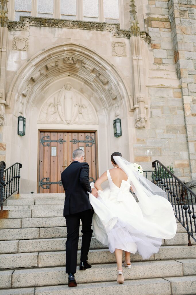 Bride walking into Saint Ignatius church in Boston with the help of her dad