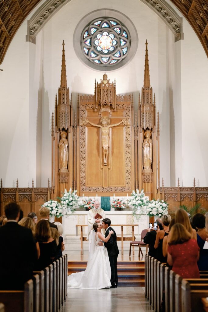 Bride and groom first kiss at Saint Ignatius church in Boston