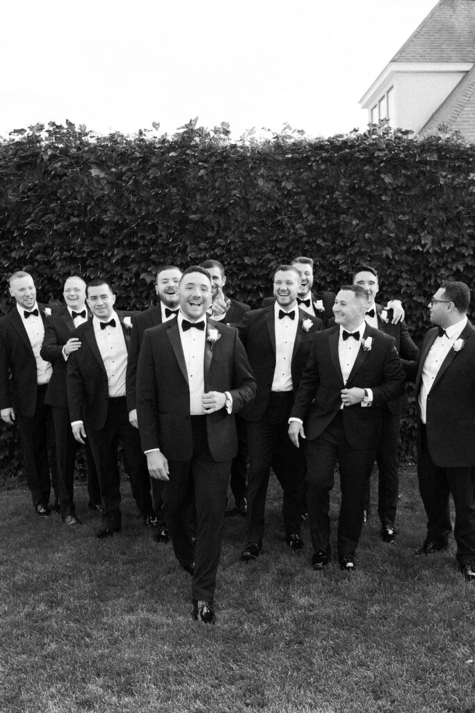 Black and white candid photo of groom and groomsmen for Belle Mer wedding in Newport, RI