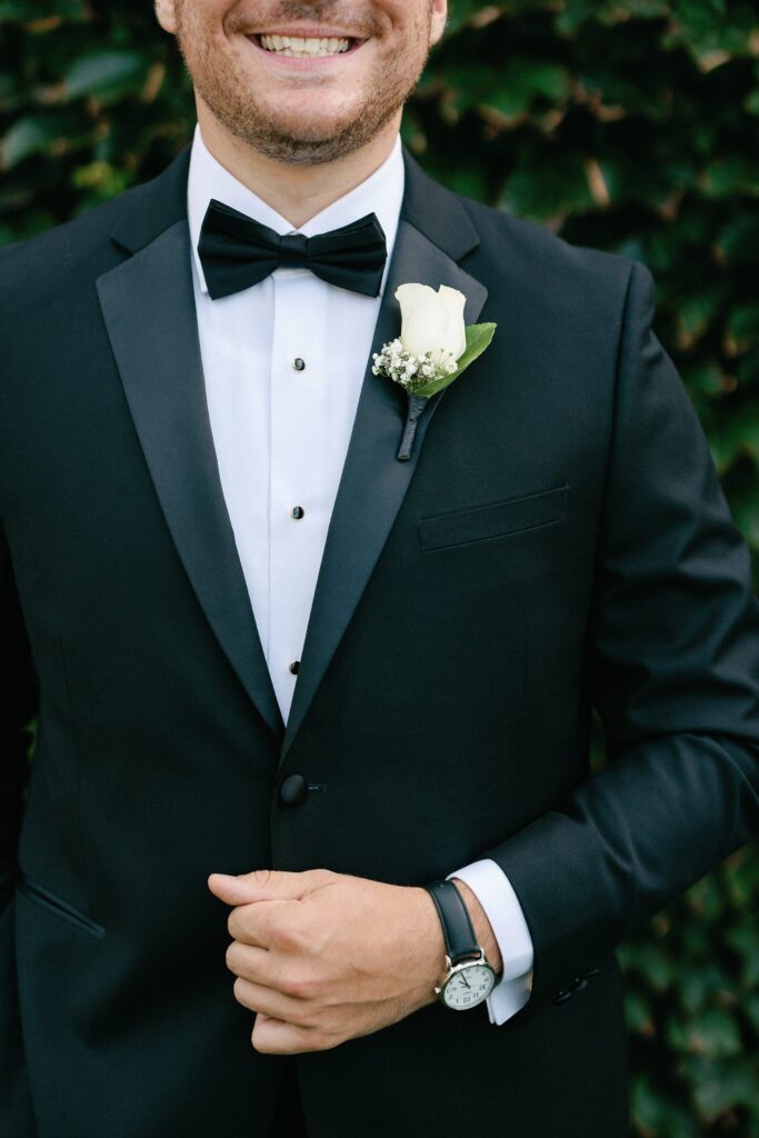 Groom detail shot wearing a tux  with boutonniere and watch for Newport wedding