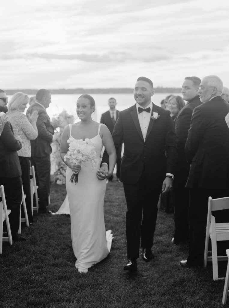 Black and white photo of bride walking down the aisle together