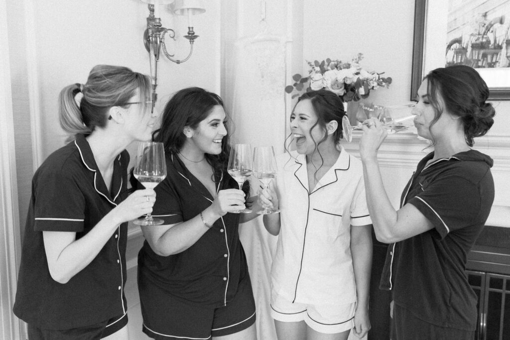 Bride and bridesmaids sipping champagne before Boston wedding 