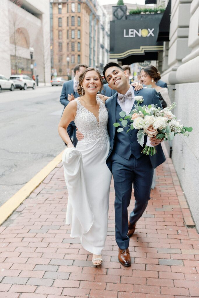 Candid photo of bride and groom walking on the street of Boston