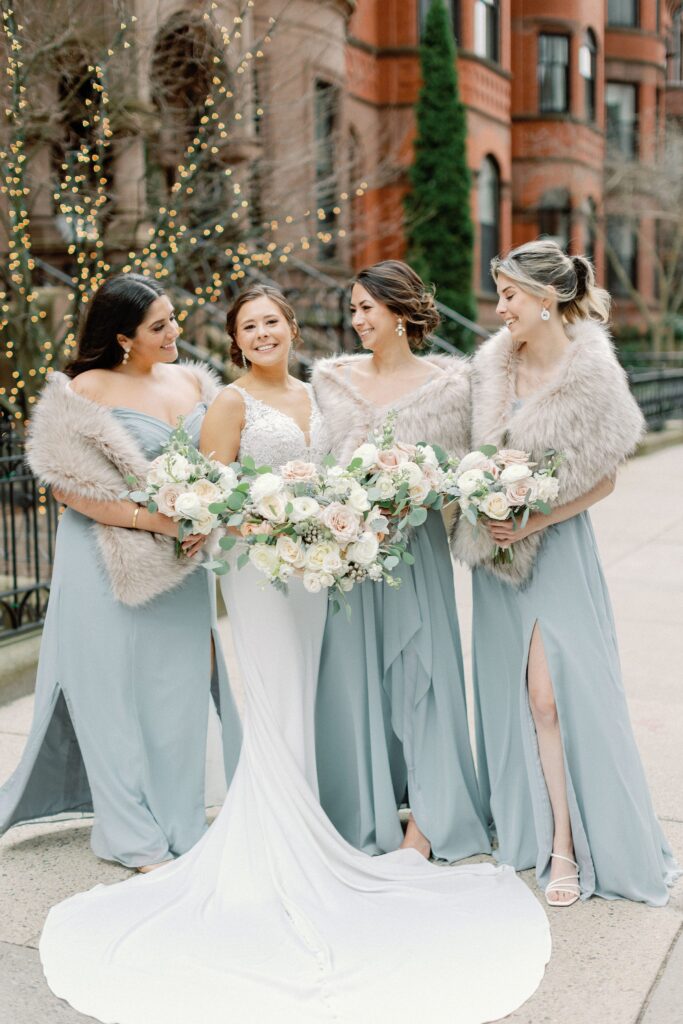 Bridesmaids in fur wrap and holding bouquets for Boston winter wedding at The Lenox Hotel