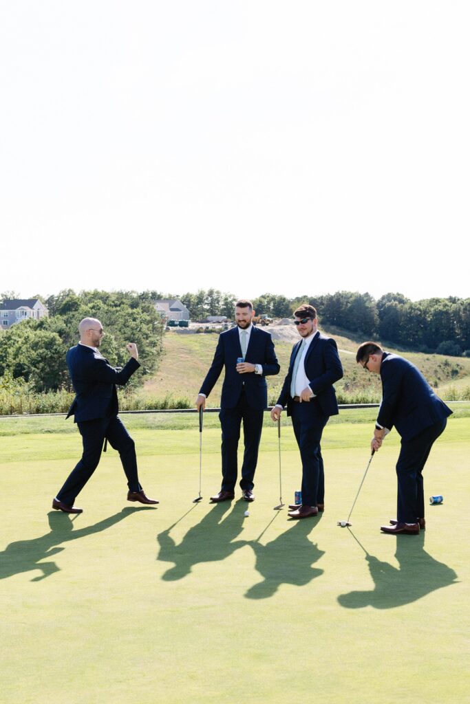 Groom and groomsmen golfing on putting green before wedding