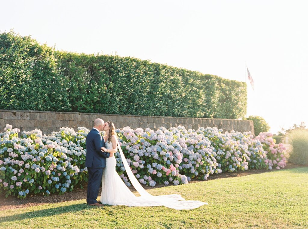 Bride and groom portrait at the Wychmere Beach Club on Cape Cod with blooming hydrangeas in the background