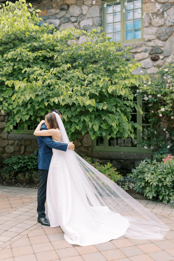 Bride and groom hugging during first look before wedding at Willowdale Estate courtyard