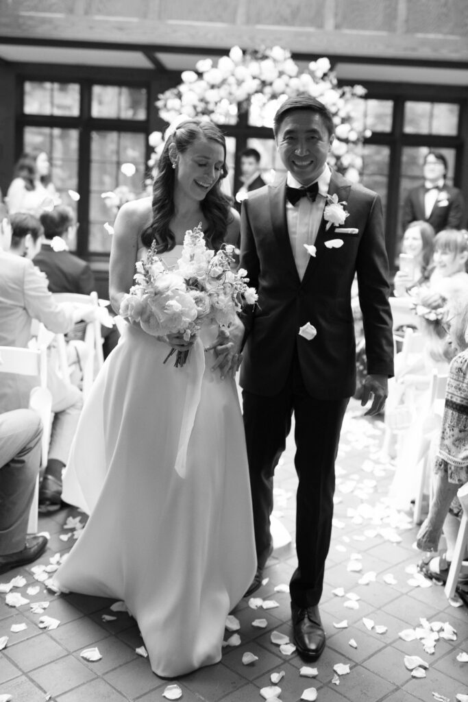Black and white photo of bride and groom after indoor wedding ceremony