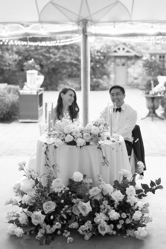 Black and white candid photo of bride and groom at wedding reception