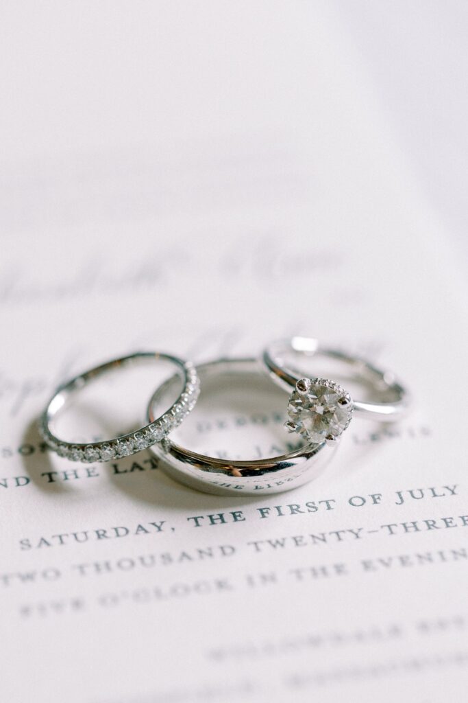 Detail photography of wedding bands and engagement ring on invitation for Willowdale wedding