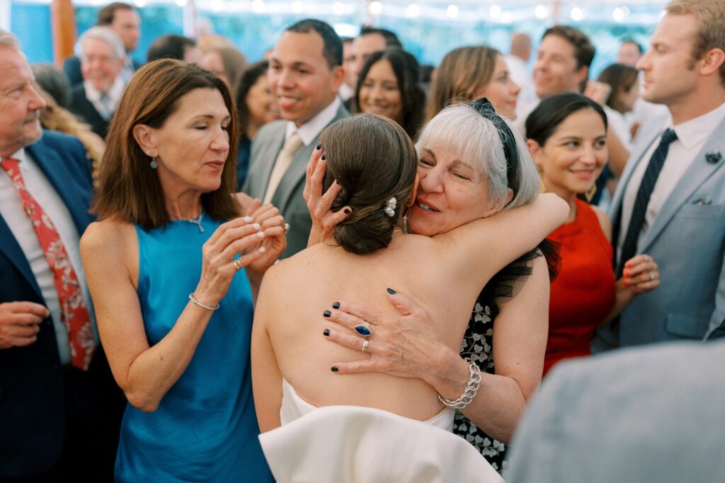 Candid photo of bride hugging family members