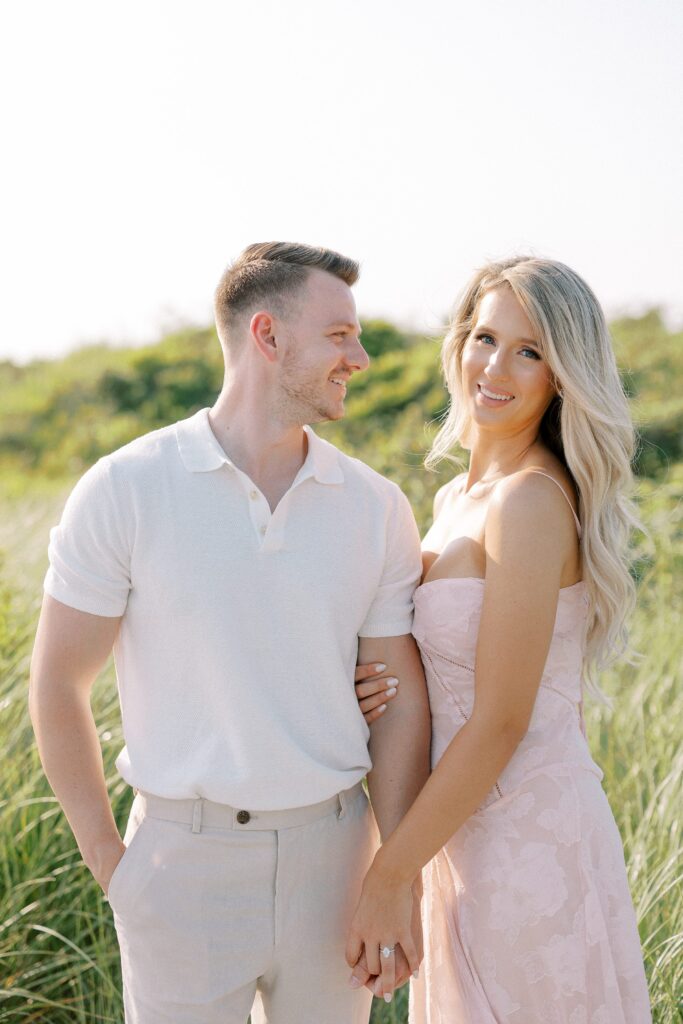 Couple beach portraits with woman wearing a pink designer dress