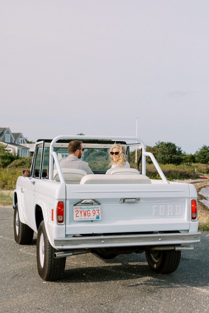 Couple portraits driving a blue Ford bronco on Martha's Vineyard
