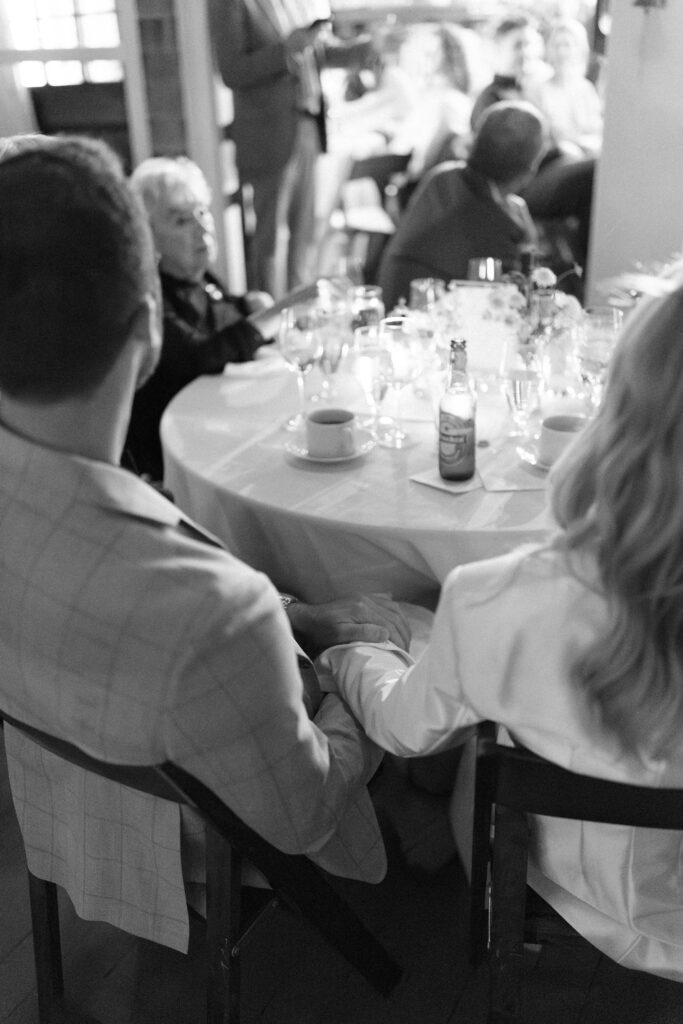 Black and white photo of bride and groom holding hands during Martha's Vineyard rehearsal dinner