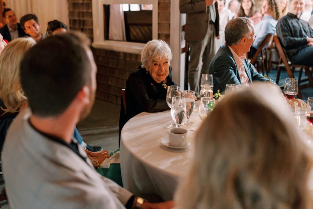 Candid photo of grandmother smiling during rehearsal dinner 