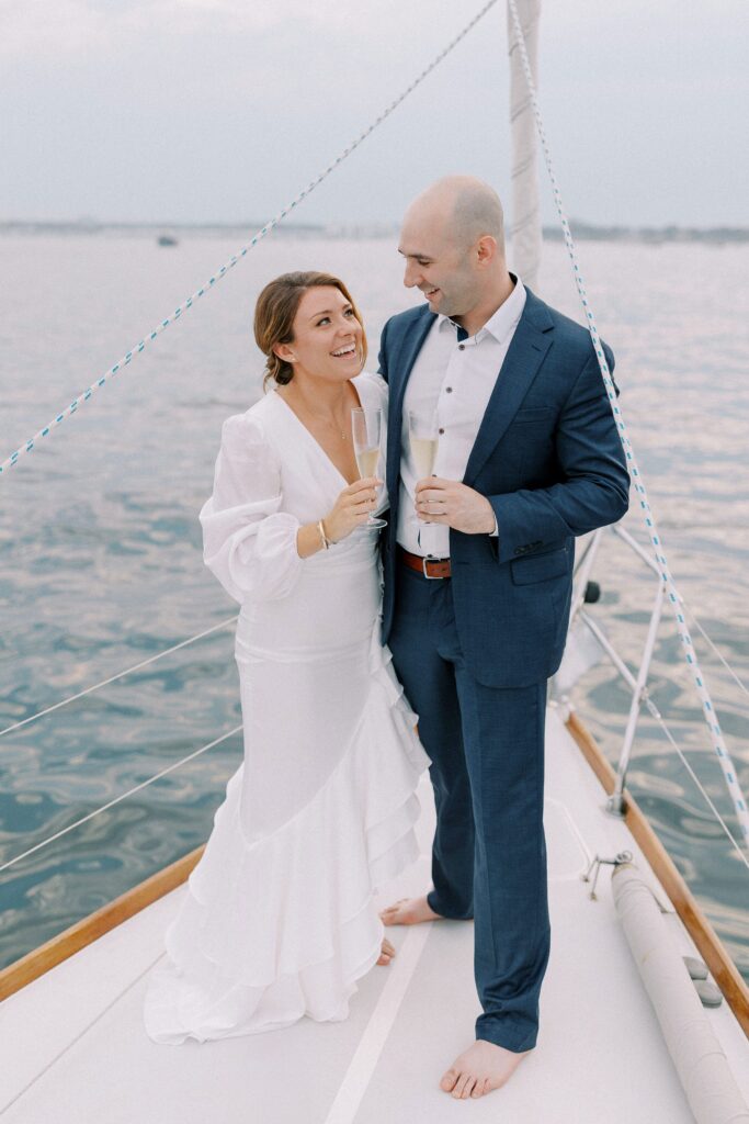 Couple holding champagne glasses on sailboat