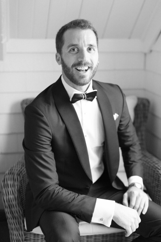 Black and white portrait of the groom getting ready for coastal tented wedding 