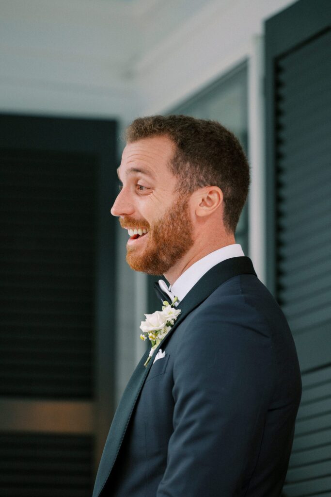 Groom's reaction to seeing bride during rainy first look on the porch of a Martha's Vineyard home