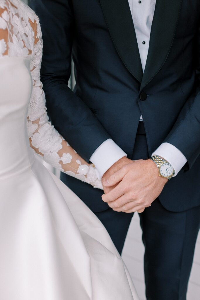 Detail photo of groom holding bride's hand