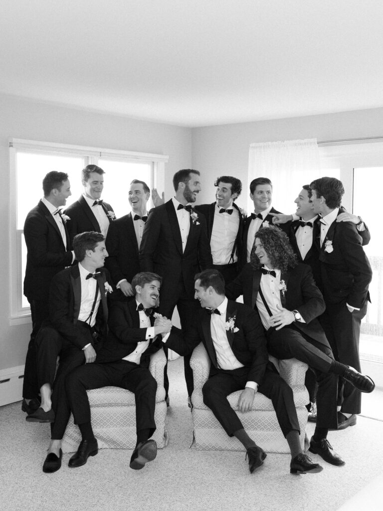 Black and white candid groom and groomsmen portrait wearing tuxes