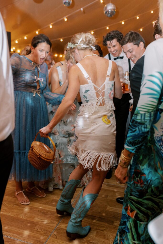 Brides outfit change at reception with cowgirl boots and pressed flowers