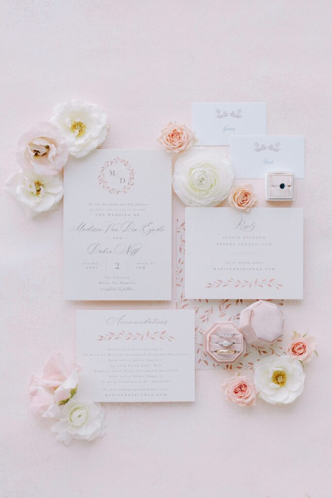 Light pink flat lay photography of the stationery and rings for New Hampshire wedding