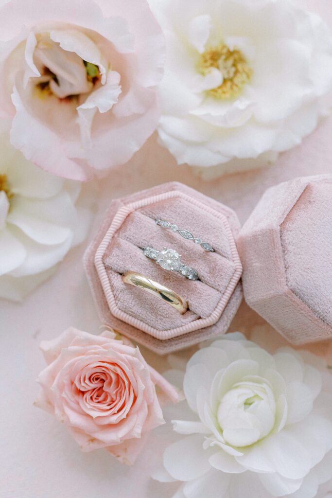 Detail photography of wedding bands and engagement ring in pink velvet box 