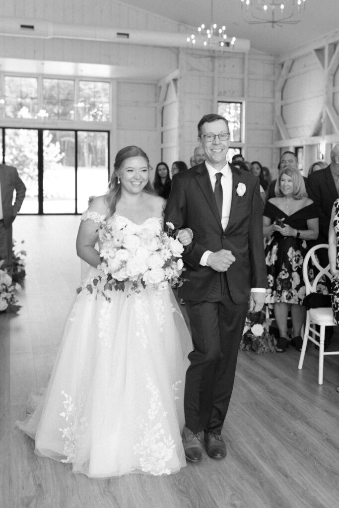 Black and white photo of bride walking down the aisle with her dad for New England wedding