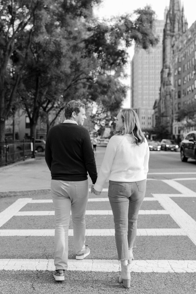Black and white photo of couple walking hand in hand on Comm Ave in Boston