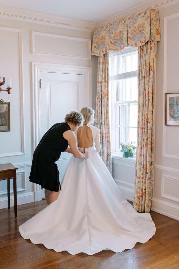 Bride getting ready with the help of her mom for Newport wedding