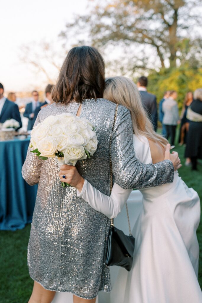 Bride hugging a guest during cocktail hour at the New York Yacht Club Harbour Court in Newport, RI