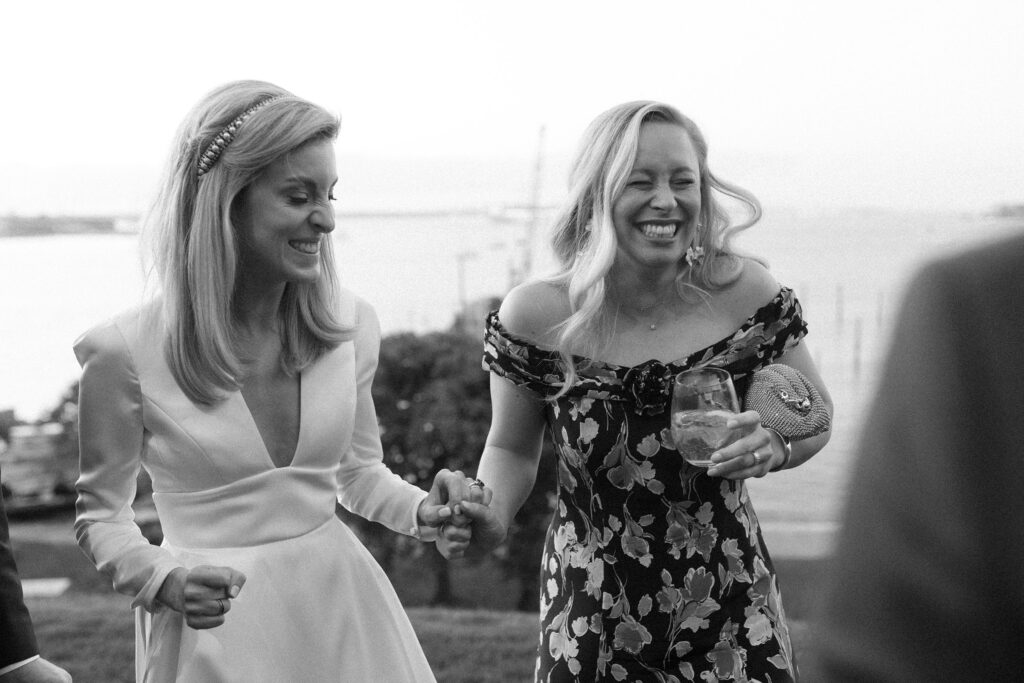 Black and white candid photo of bride and guest laughing for New England wedding